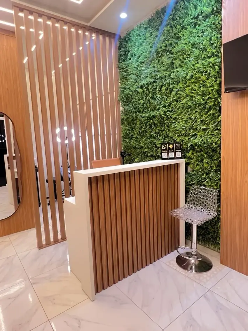 Recepção do Studio, com parede de jardim vertical e balcão em madeira