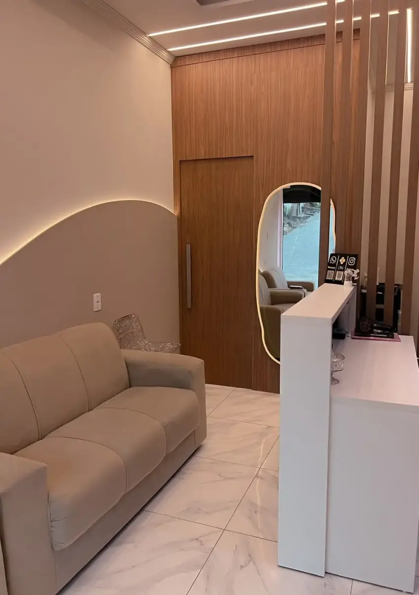 Sala de espera com sofá e espelho arqueado
